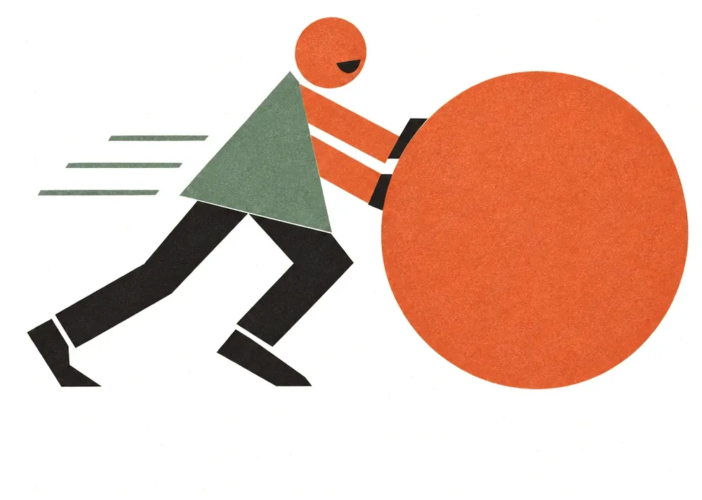 A worker cheerfully pushing a huge orange ball forward